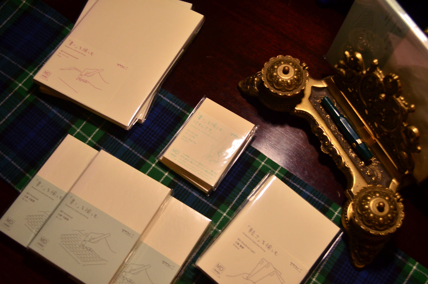 Desk with rows of various sizes of Midori journals and notebooks.